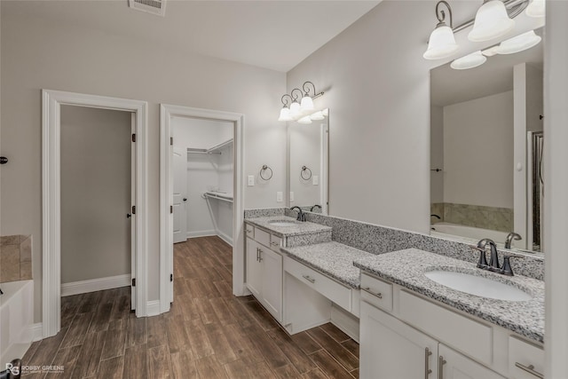 bathroom featuring wood-type flooring, a bathing tub, and vanity