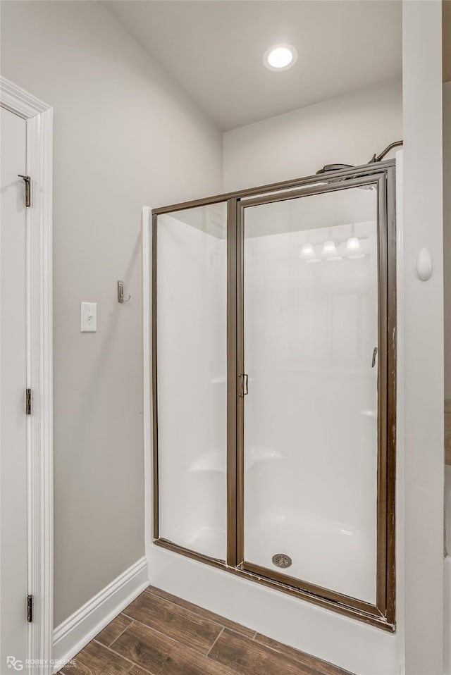 bathroom featuring a shower with shower door and hardwood / wood-style floors