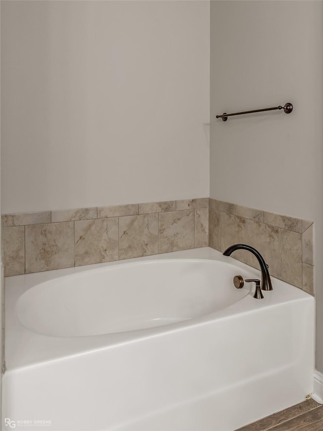 bathroom with hardwood / wood-style flooring and a washtub