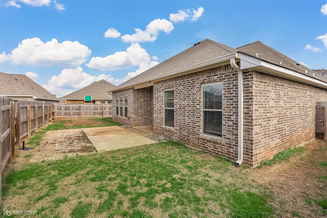 back of property with a yard and a patio