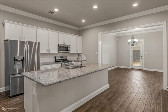 kitchen featuring appliances with stainless steel finishes, sink, white cabinets, light stone counters, and a center island with sink