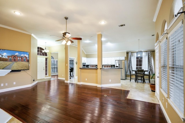 unfurnished living room featuring hardwood / wood-style flooring, lofted ceiling, ornamental molding, and ceiling fan with notable chandelier