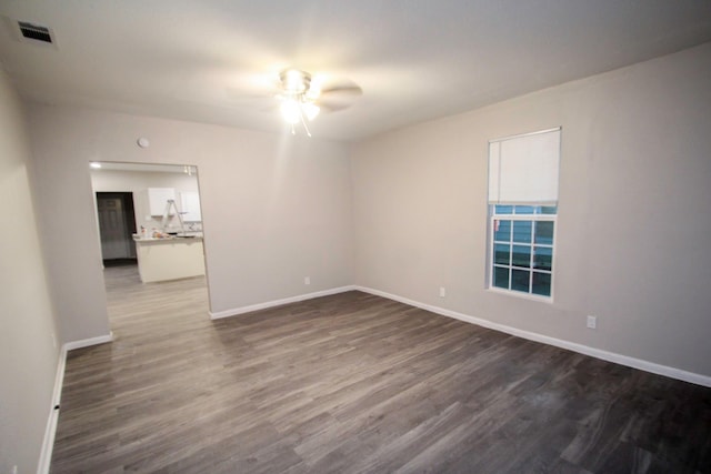 unfurnished room with dark wood-type flooring and ceiling fan