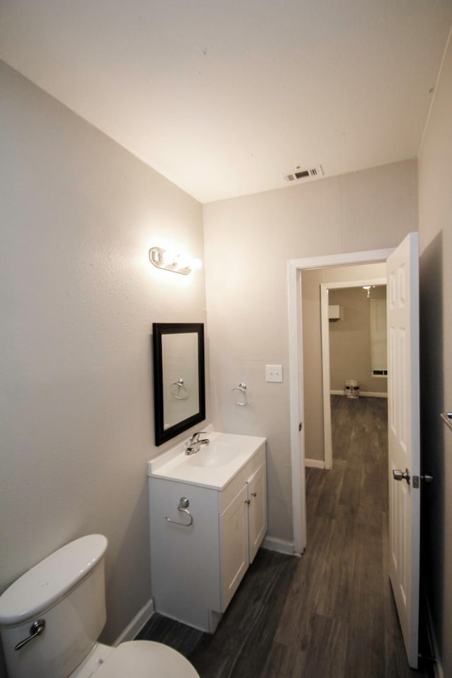 bathroom with vanity, hardwood / wood-style flooring, and toilet