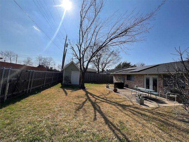 view of yard with french doors, a patio, and a storage unit