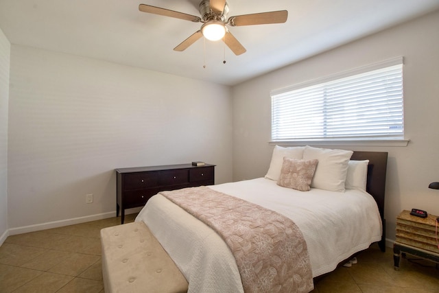 bedroom with a ceiling fan, baseboards, and light tile patterned floors