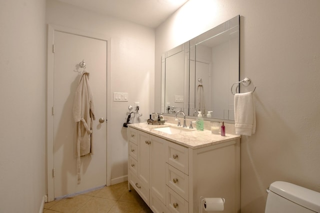 bathroom with toilet, vanity, and tile patterned floors