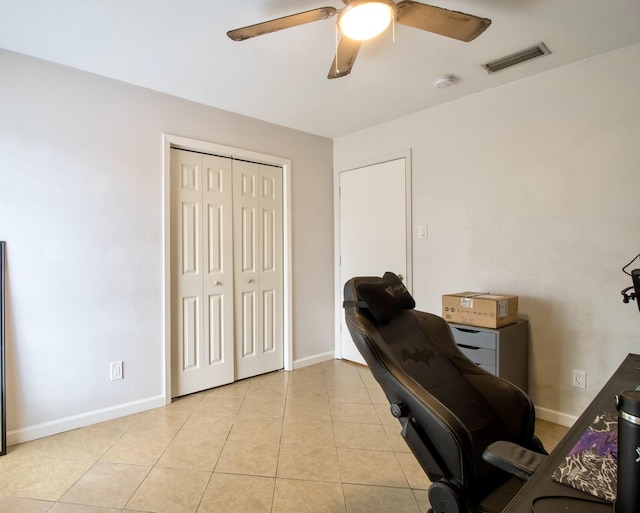 office with light tile patterned floors, baseboards, visible vents, and a ceiling fan