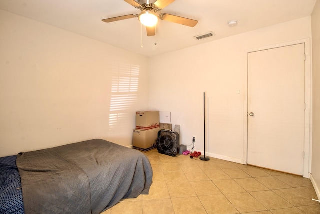 bedroom featuring a ceiling fan, visible vents, and light tile patterned floors