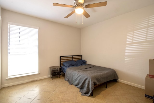 bedroom with light tile patterned floors, baseboards, and a ceiling fan