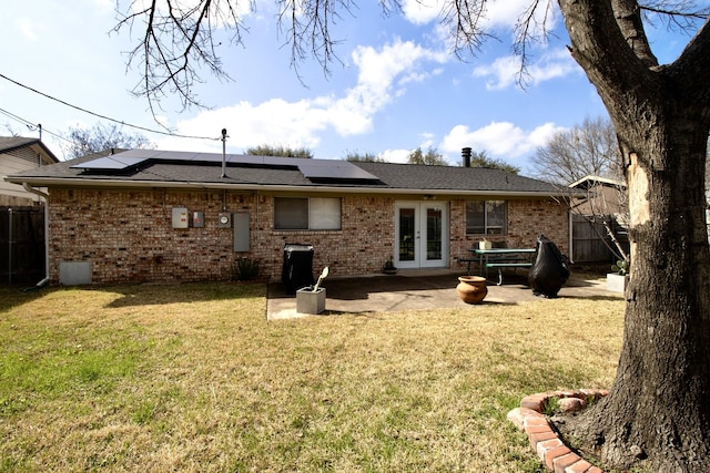 rear view of property featuring french doors, a lawn, a patio area, and brick siding