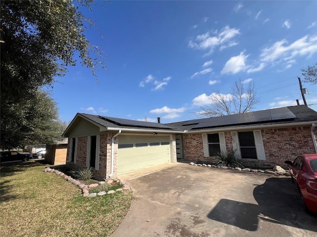 ranch-style house with a garage, a front lawn, and solar panels