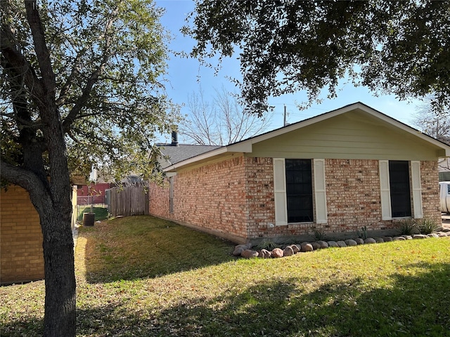 view of side of property with central air condition unit and a lawn