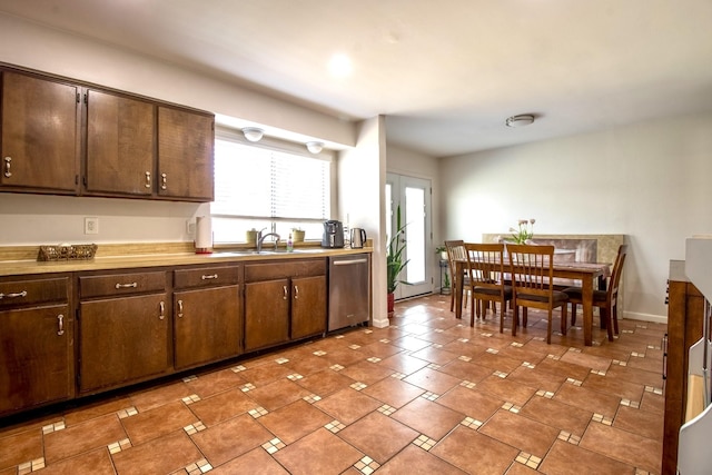 kitchen with baseboards, dishwasher, a sink, and dark brown cabinets