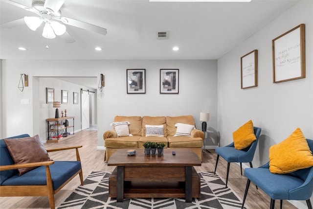 living room featuring light hardwood / wood-style flooring and ceiling fan