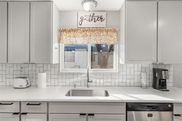 kitchen featuring tasteful backsplash, dishwasher, sink, and white cabinets