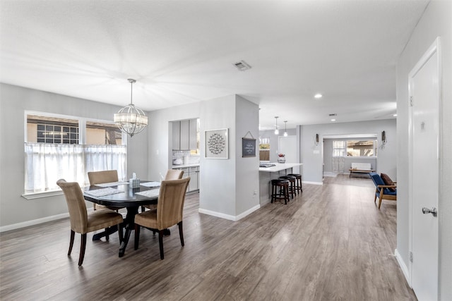 dining area featuring hardwood / wood-style flooring and a notable chandelier