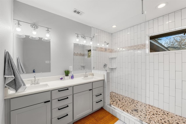 bathroom with vanity and tiled shower