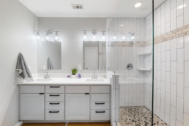 bathroom with tiled shower and vanity