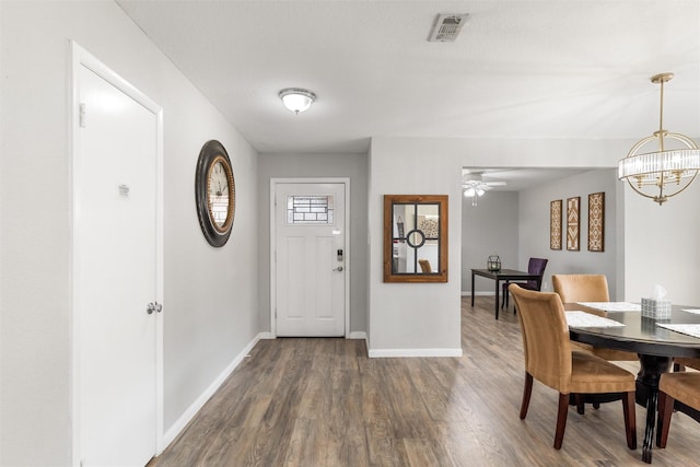 foyer with dark hardwood / wood-style flooring and ceiling fan with notable chandelier