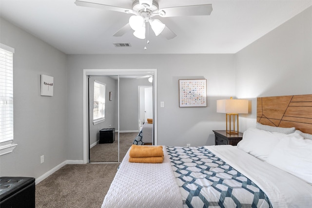 bedroom with dark colored carpet, ceiling fan, and a closet