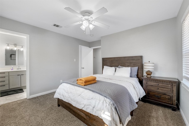 bedroom featuring dark colored carpet, sink, ceiling fan, and ensuite bath