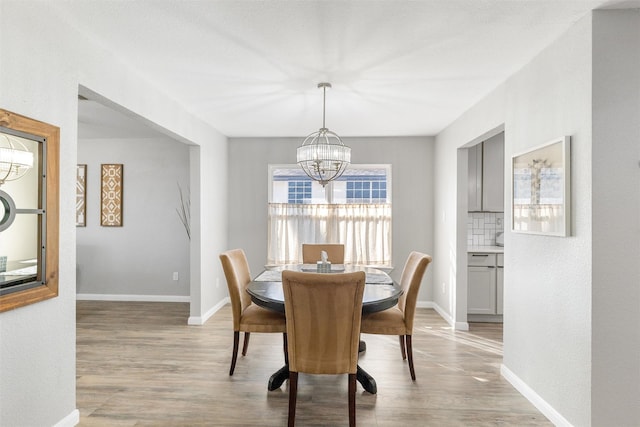 dining space with a chandelier and light hardwood / wood-style flooring