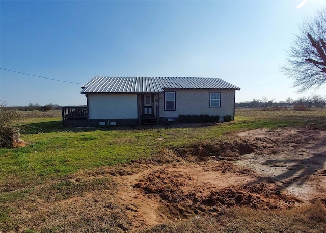 rear view of property featuring a yard and a rural view