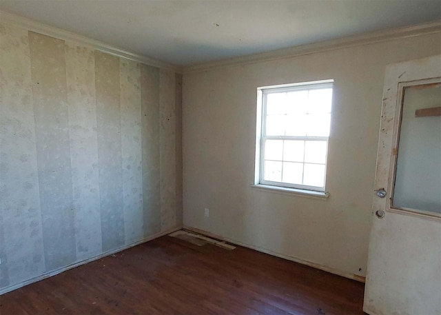 empty room with ornamental molding and dark hardwood / wood-style flooring