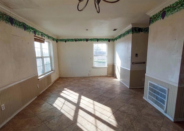 spare room featuring crown molding and a healthy amount of sunlight