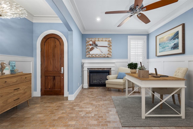 office space featuring crown molding, ceiling fan, and a premium fireplace