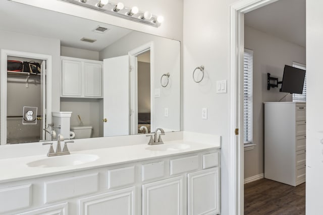 bathroom featuring vanity, toilet, and hardwood / wood-style floors