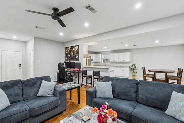 living room featuring light hardwood / wood-style floors and ceiling fan