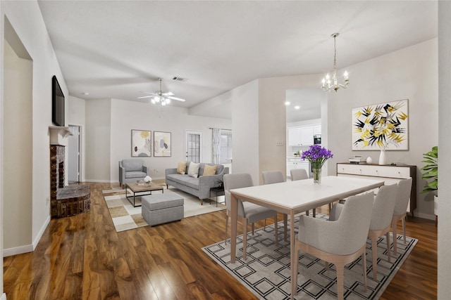 dining area featuring a brick fireplace, visible vents, baseboards, and wood finished floors