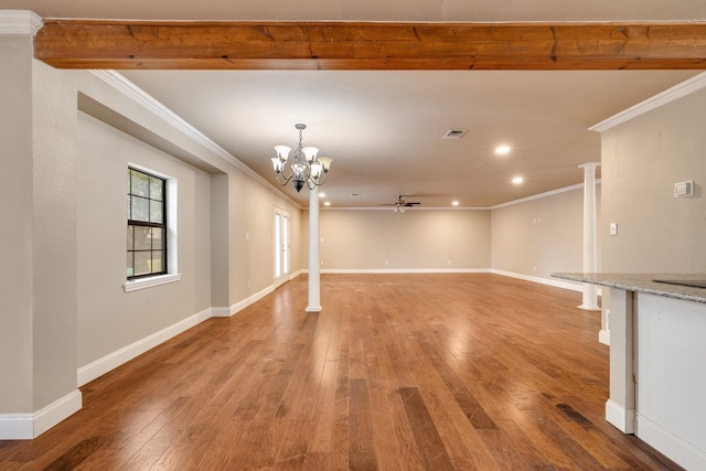 unfurnished living room featuring hardwood / wood-style floors, crown molding, and ornate columns