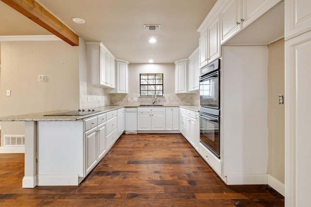 kitchen with sink, white cabinetry, black appliances, light stone countertops, and backsplash