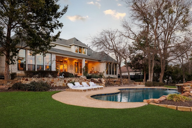 back of house featuring a patio, a yard, and an outdoor pool