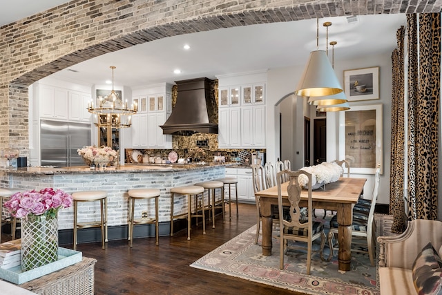 dining area featuring dark hardwood / wood-style floors and an inviting chandelier