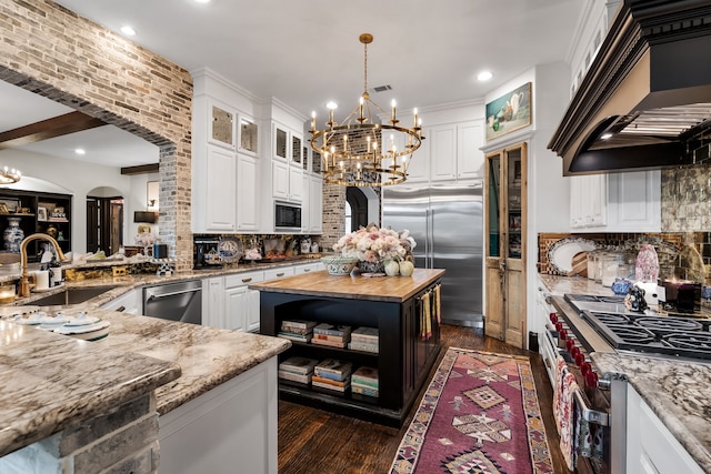 kitchen with white cabinetry, premium range hood, butcher block counters, and built in appliances