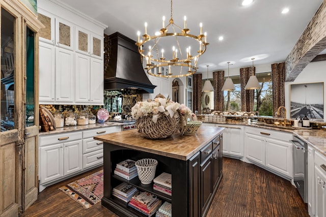 kitchen featuring custom exhaust hood, white cabinetry, and pendant lighting