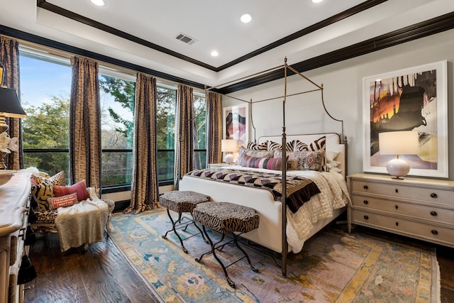 bedroom with crown molding, a tray ceiling, and dark hardwood / wood-style floors