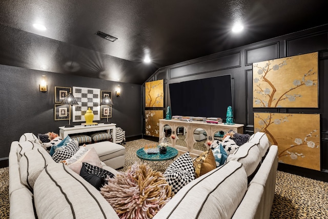 home theater featuring vaulted ceiling, a textured ceiling, and carpet flooring