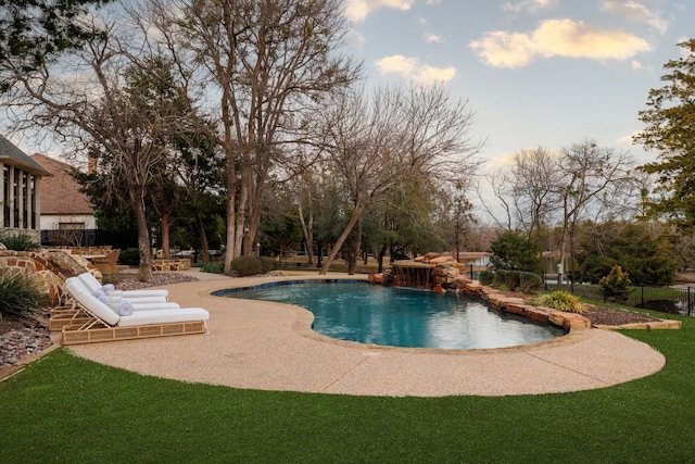 view of swimming pool with pool water feature and a lawn