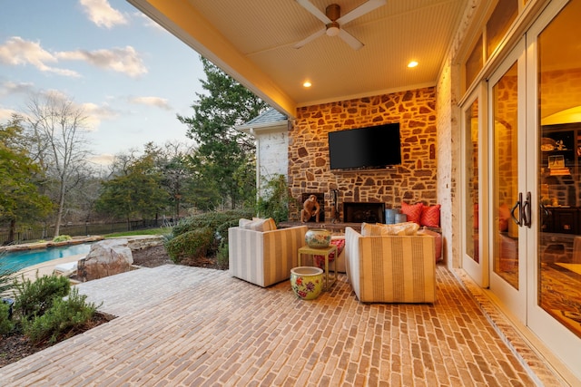 view of patio / terrace featuring a fenced in pool, an outdoor living space with a fireplace, french doors, and ceiling fan