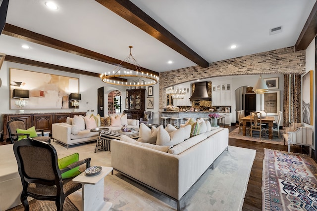 living room with beamed ceiling, brick wall, and light hardwood / wood-style floors