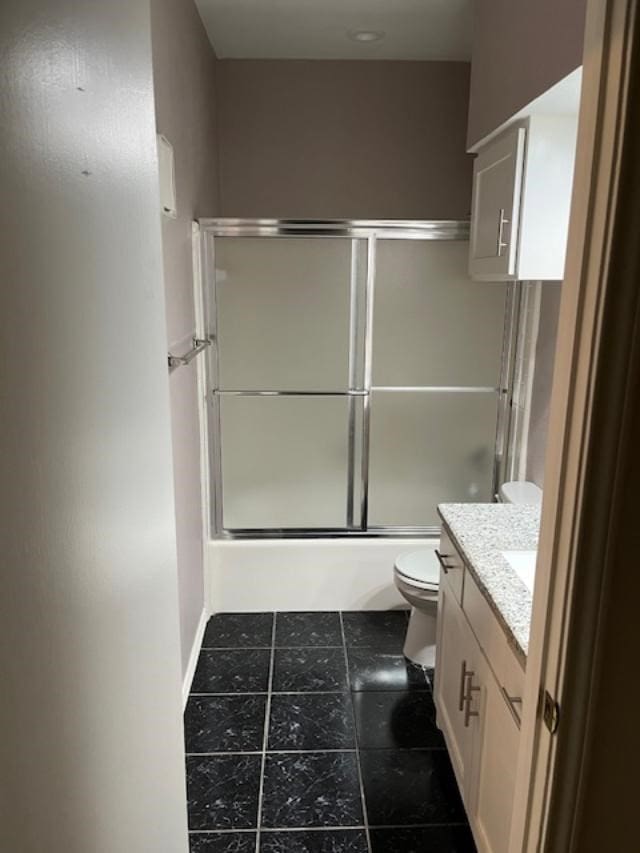 full bathroom featuring vanity, tile patterned flooring, enclosed tub / shower combo, and toilet