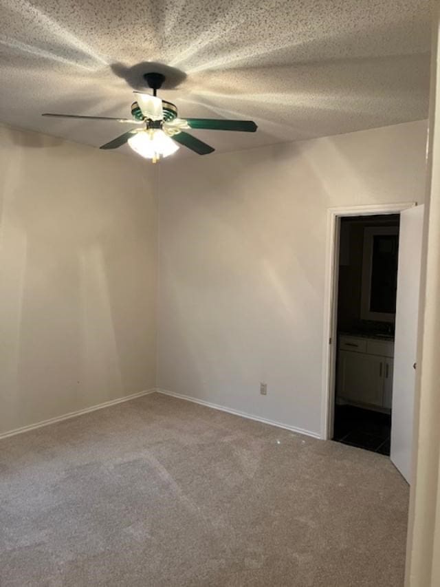 unfurnished room with ceiling fan, a textured ceiling, and carpet flooring