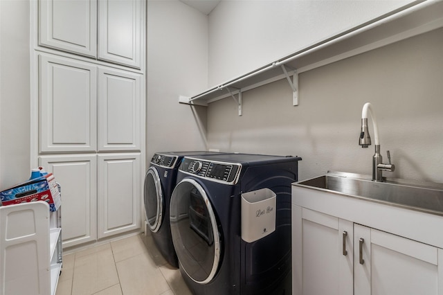 washroom with sink, separate washer and dryer, light tile patterned flooring, and cabinets