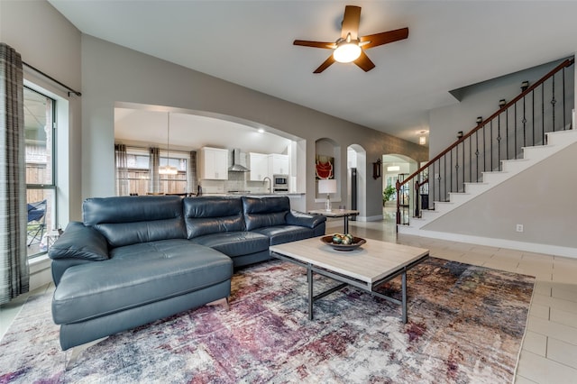 tiled living room featuring ceiling fan and sink