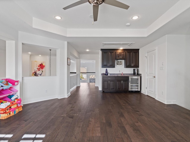 kitchen featuring sink, dark brown cabinets, dark hardwood / wood-style floors, wine cooler, and a tray ceiling